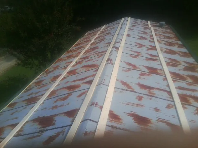 Rusted metal roof panels with new wood purlins before replacement — Storm Damage Roof Repair in Caliente by Roofing Brothers