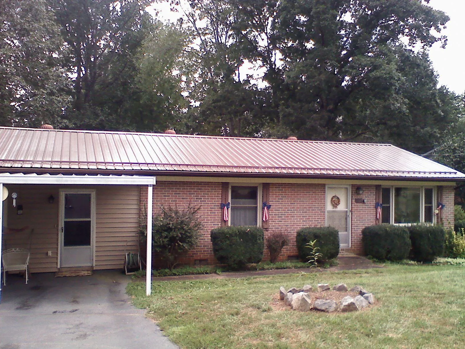 Bronze metal roof and carport on a brick ranch home — Roof Repair work by our crew in Caliente